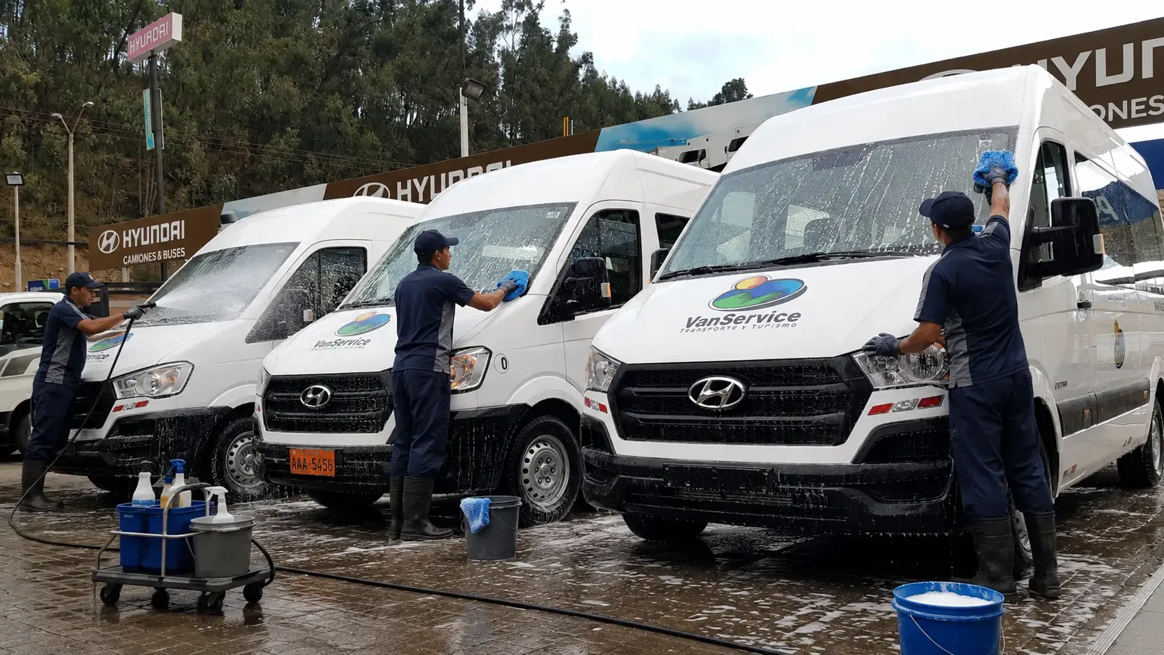 Equipo lavando una flotilla de vans blancas estacionadas en fila